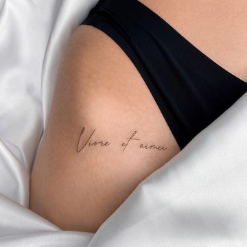 Tattoo lettering on a woman's thigh