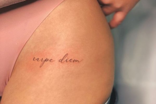 Tattoo lettering on a woman's thigh